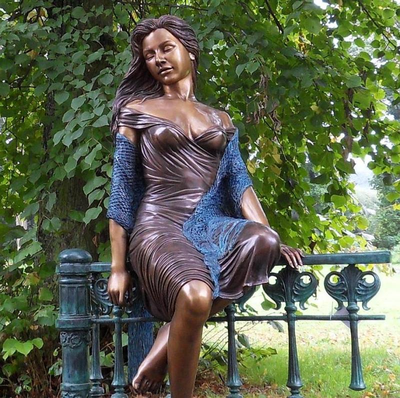 Frau Bronze Figur auf Zaun