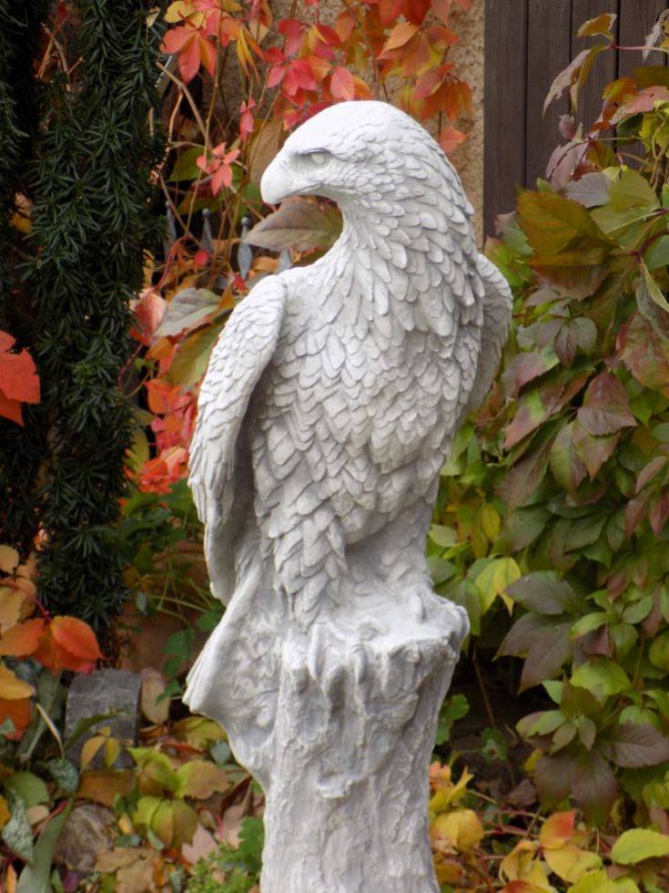 Adler Steinfigur auf Baumstamm